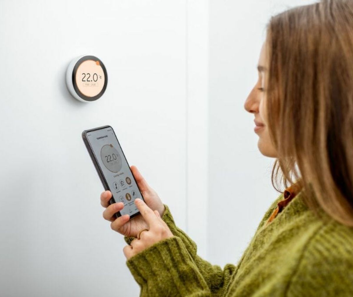 Woman adjusting a smart thermostat using a phone app