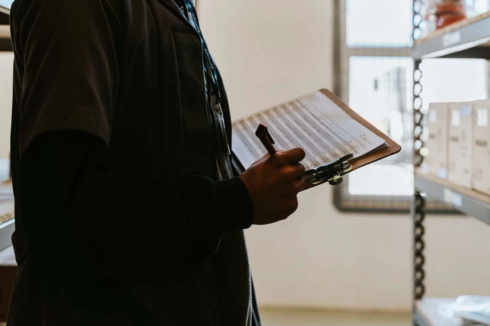 HVAC technician holding a clipboard by a unit