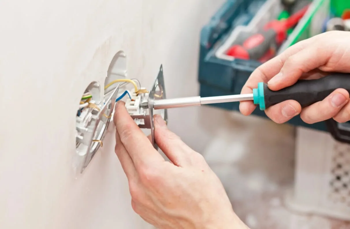 Licensed electrician working safely inside a home electrical panel