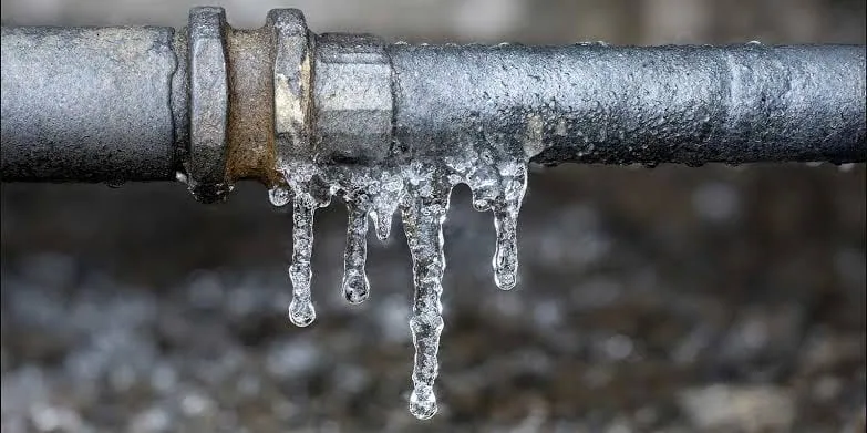 Frozen residential water pipe with icicles hanging from it