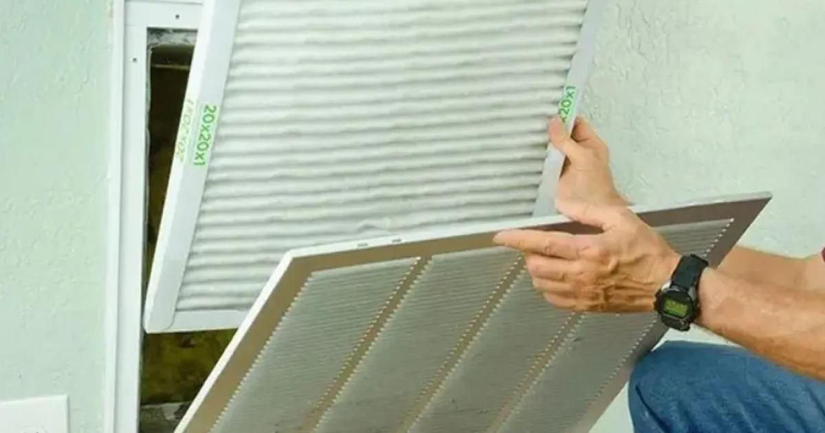 Person removing a return air grille to change the furnace filter
