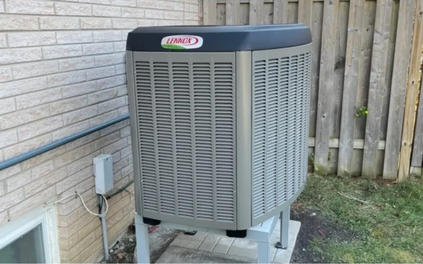 Air-source heat pump unit installed outside a home in winter