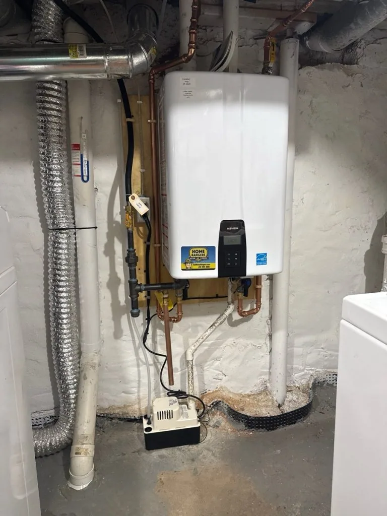 Wall-mounted tankless water heater with copper supply lines in a basement