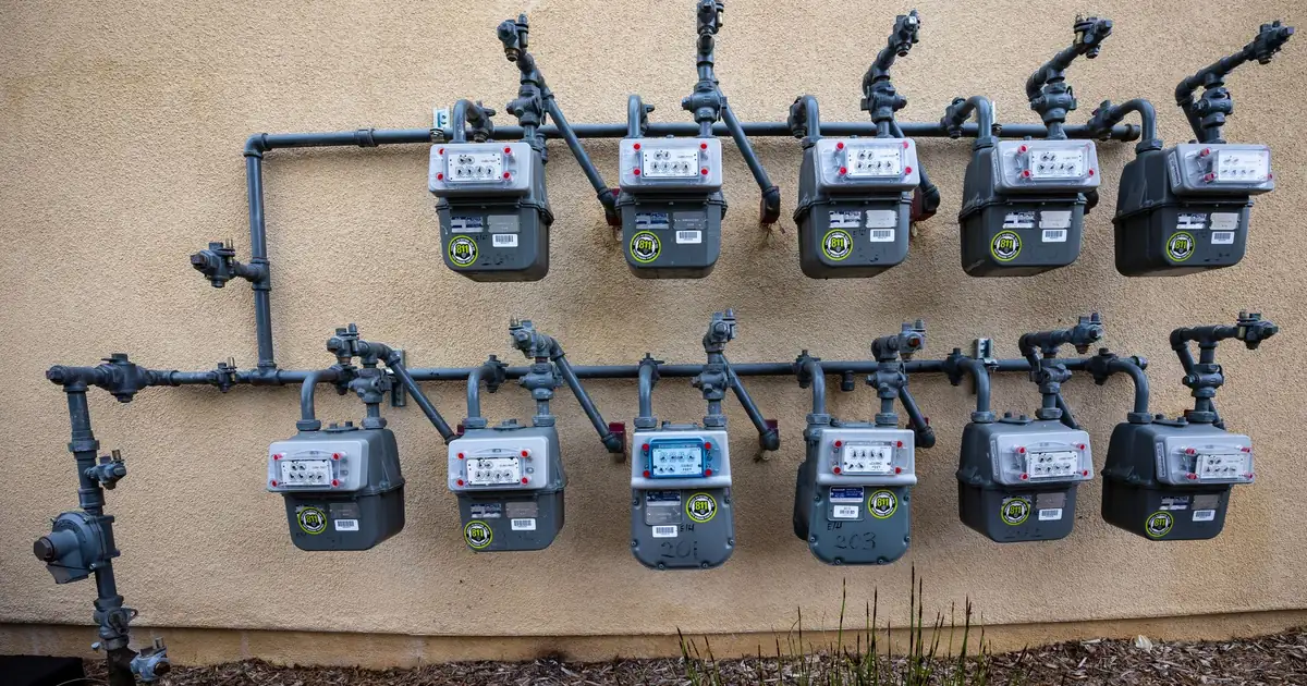 Row of residential natural gas meters mounted on an outside wall