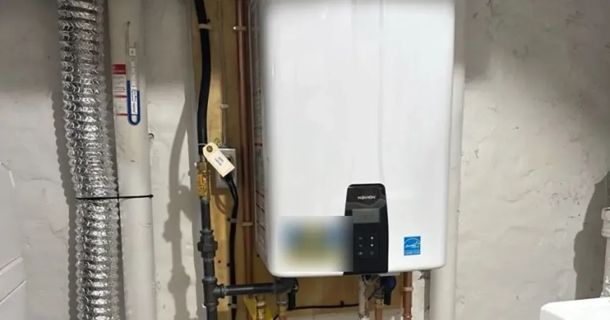 Wall-mounted gas tankless water heater with copper piping in a basement