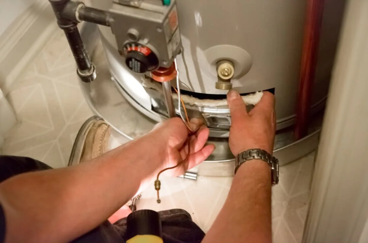 Technician inspecting a residential water heater tank