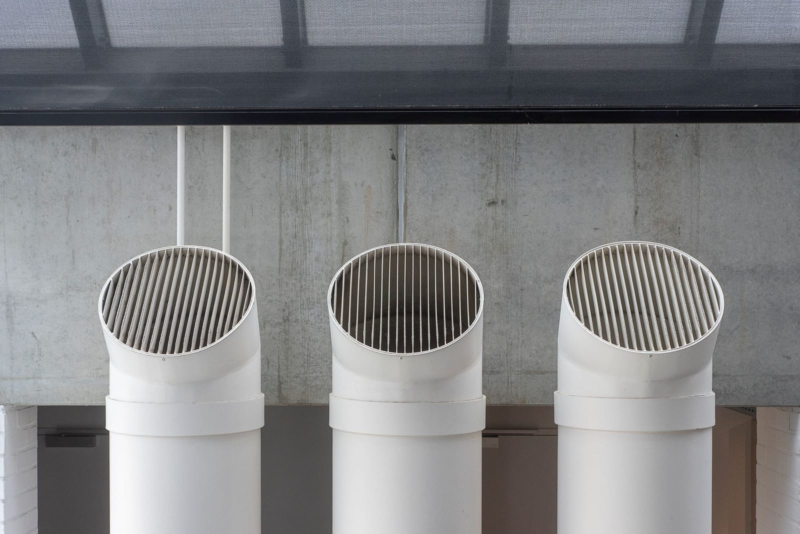 White PVC furnace venting pipes on a home exterior