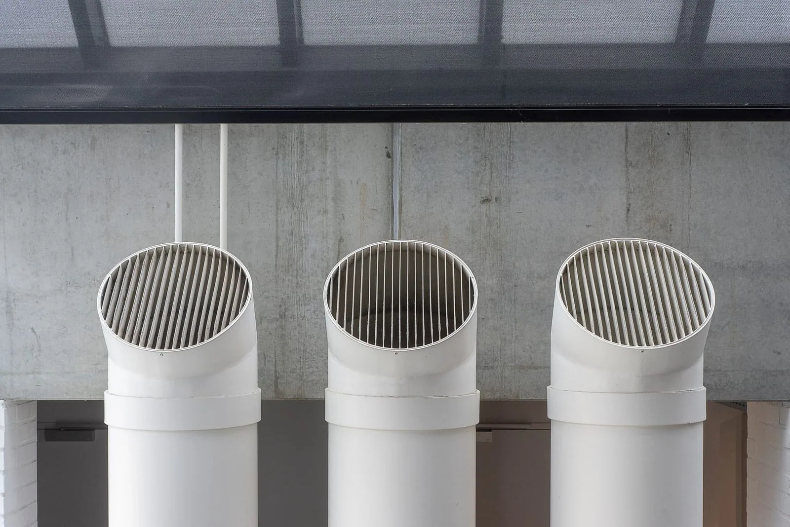 White PVC furnace venting pipes on a home exterior